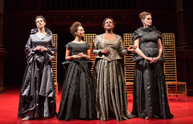 The four Elizabeths stand in front of the chairs, three with hands folded at waiste, Feamster third from left gesturing with her hands as she speaks.