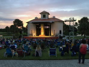 Photo of theater lit and crowd watching play